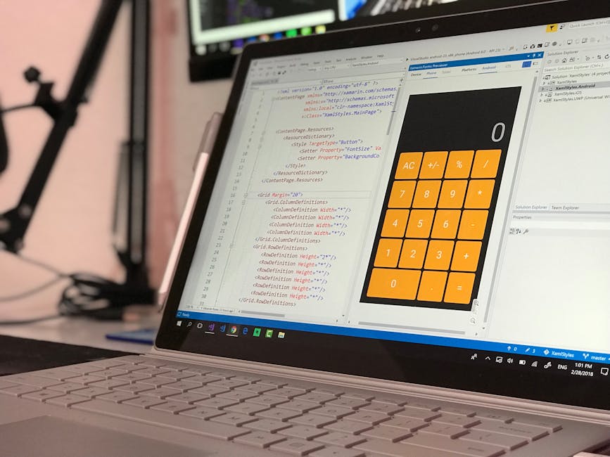 A close-up view of a laptop computer on a desk, displaying a screen with code in HTML and CSS on the left side, and a large, simplified digital calculator interface with orange buttons on the right si